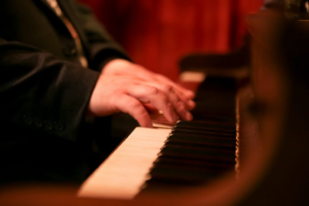 Tightly cropped photo of a man playing piano.